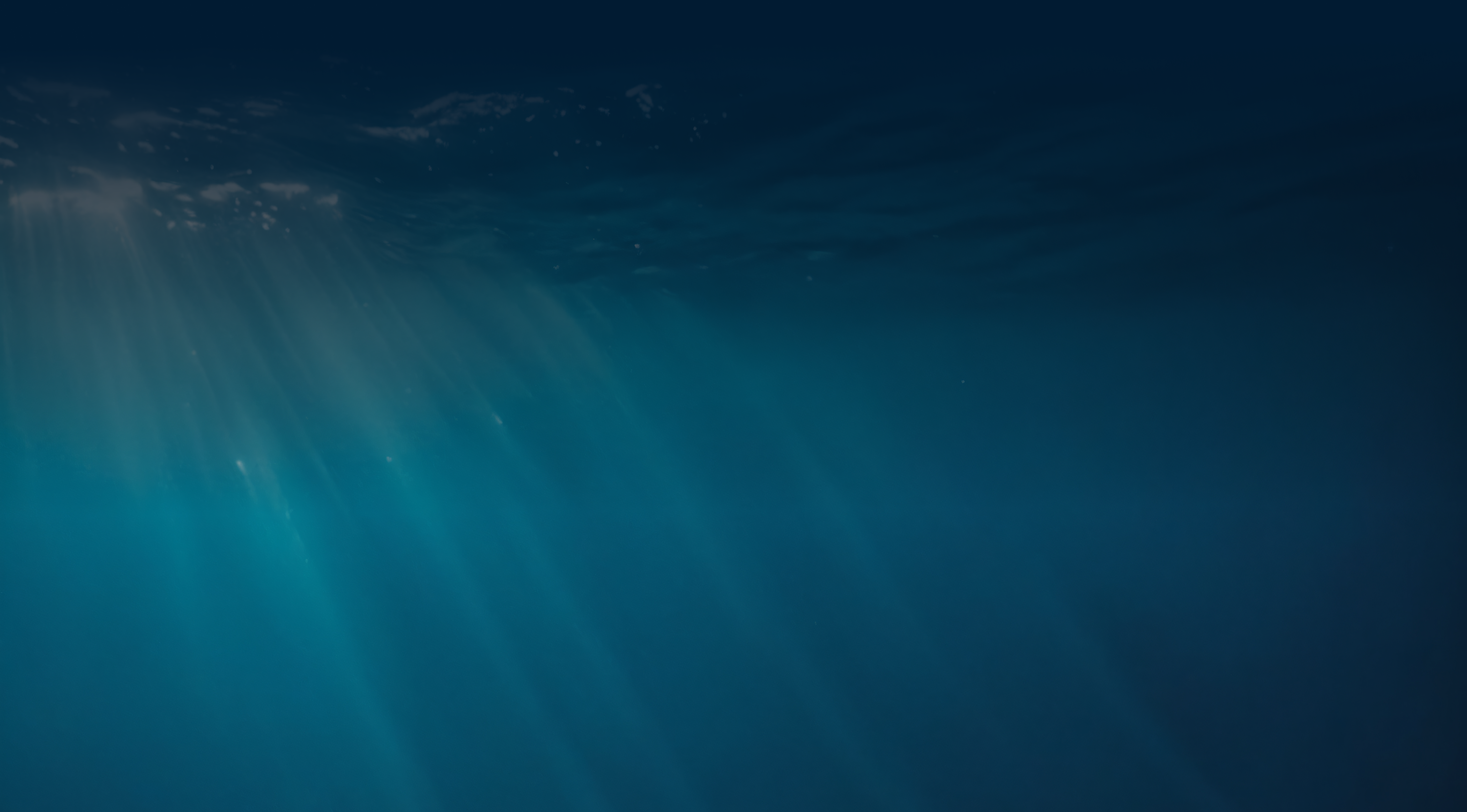 Sun rays filtering through deep blue ocean water.